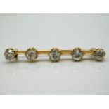 A gold bar brooch set with five old cut diamonds of approx. 2.35ct, est. colour M, electronically te