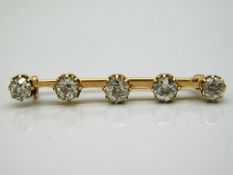 A gold bar brooch set with five old cut diamonds of approx. 2.35ct, est. colour M, electronically te