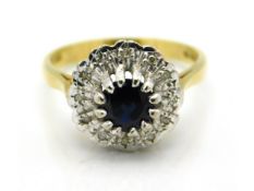 An 18ct gold ring set with diamond & central sapphire, 4.4g, size M