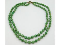 An art deco period 1920s jade double strand jade necklace, total length 32in, 54g