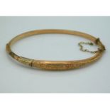 An antique 9ct gold bangle with chased decor, 61mm