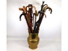 A collection of walking canes in brass stick stand