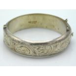 A 1968 Birmingham silver bangle with chased decor,