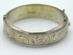 A 1968 Birmingham silver bangle with chased decor,