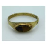 A yellow metal antique ring set with tiger eye, el