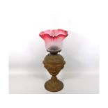 A 19thC. oil lamp with period etched cranberry sha