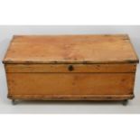 An antique pine box on castors, 37in wide x 18.5in