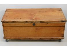 An antique pine box on castors, 37in wide x 18.5in
