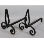 A pair of wrought iron fire dogs, 16in long x 12in