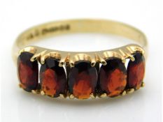 A 9ct gold five stone garnet ring, size R/S, 2.5g
