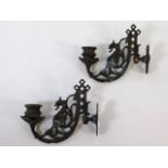 A pair of ornate brass wall sconces depicting drag