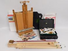 Two painting easels, a quantity of paints, brushes & other artist accessories