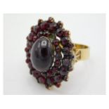 A yellow metal garnet cluster ring with central ca