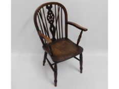 An oak framed wheel back arm chair with elm seat