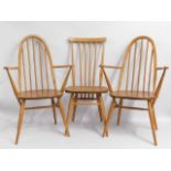 A pair of Ercol light elm carvers twinned with an earlier Ercol stick back chair, some staining to s