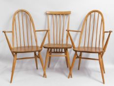A pair of Ercol light elm carvers twinned with an earlier Ercol stick back chair, some staining to s