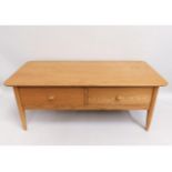 A blond oak coffee table with drawers believed to