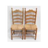 A pair of oak rush seat ladder back dining chairs,