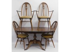 An extending Ercol elm table with two carvers & tw