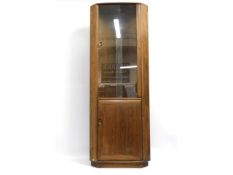 An Ercol elm "Windsor" corner cabinet with glass d