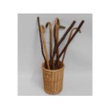 A wicker stick basket with four walking canes & ot
