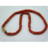 An antique coral necklace with yellow metal clasp