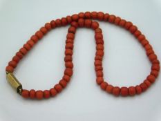 An antique coral necklace with yellow metal clasp