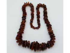 A large antique amber chip necklace, 27in long, 90