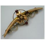 A 9ct gold brooch with floral decor set with garne