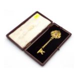 A cased silver gilt key with decorative enamelled
