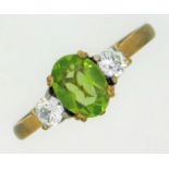 A 9ct gold ring set with peridot & white paste sto