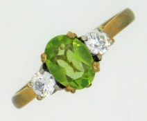 A 9ct gold ring set with peridot & white paste sto