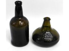 An 18thC. wine bottle, 9.375in tall, twinned with