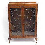 An oak art deco bookcase with sunrise pattern lead