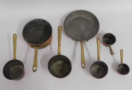 Seven tin lined copper pans with brass handles, la