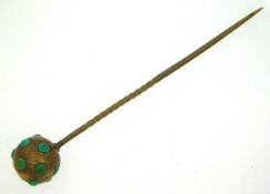 A 19thC. yellow metal tie pie set with turquoise, one stone missing, tests electronically as 9ct gol