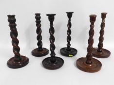 Three pairs of oak barley twist candle holders, 12