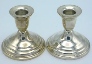 A pair of sterling silver candle holders, probably