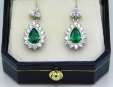 A pair of 9ct white gold diamond & emerald earring