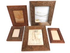 Five Chinese teak picture frames, glass a/f in one, all with carved decor including two with dragons
