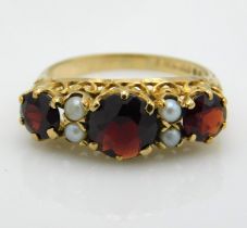 A 9ct gold open work set garnet & pearl ring, 2.8g