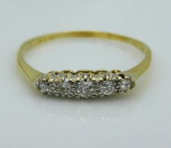 A yellow metal ring, rubbed marks, tests electronically as 18ct gold, set with five platinum set dia