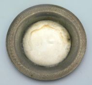 A white metal pin dish with Egyptian marks, 3in di