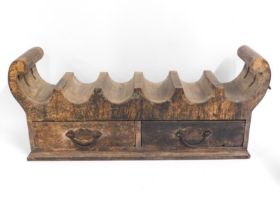 A heavy wooden six bottle wine rack with drawers,