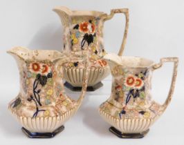 Three decorative graduated jugs, one handle has cr