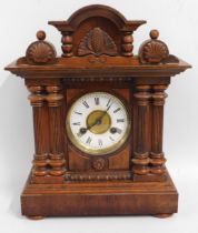 A decorative walnut mantle clock, dial framed by t