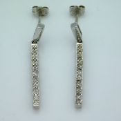 A pair of 9ct white gold diamond strand earrings,