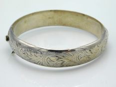 A Birmingham silver bangle with chased decor, lack