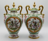 A pair of decorative continental porcelain vases, 11in tall, one lid finial repaired