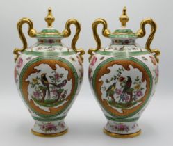 A pair of decorative continental porcelain vases, 11in tall, one lid finial repaired